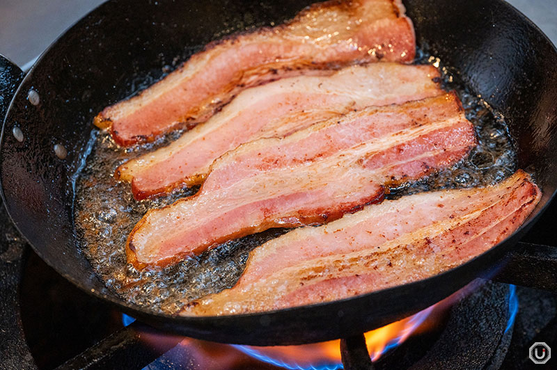 The cooking process for bacon used in Aglio e olio with bacon