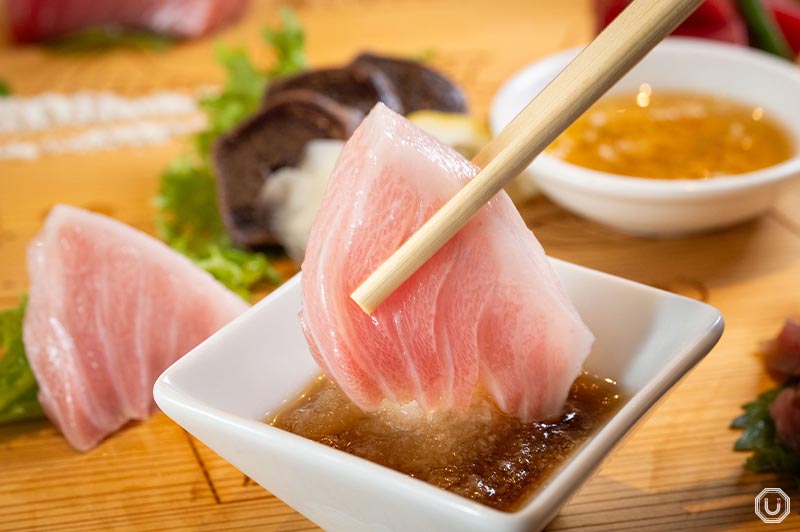 It's recommended to eat the fatty tuna sashimi with grated radish and citrus soy sauce