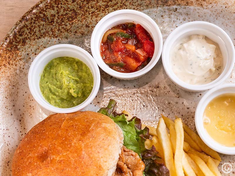 The Grilled Burger at Vegan Bistro Jangara in Harajuku comes with four types of sauces and condiments