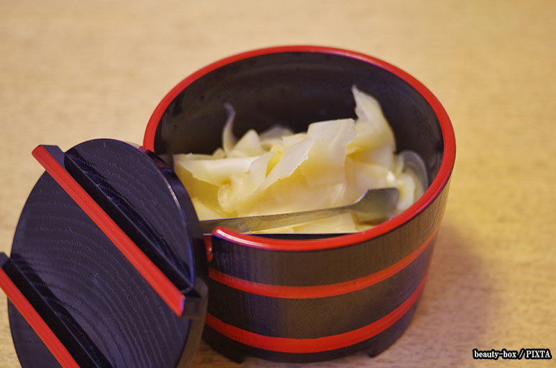 A container of pickled ginger at a sushi restaurant